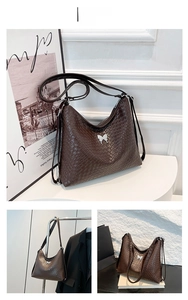 Detail of a brown woven leather tote with an elegant silver butterfly metal buckle