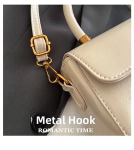 Close-up of vintage gold hardware and textured leather on a chic small crossbody bag