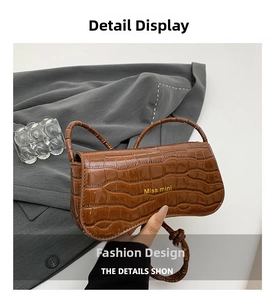 Detailed macro view of the brown crocodile pattern texture on the Miss Mini flap shoulder bag