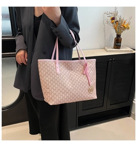 Detail of pink monogram tote bag with metallic M pendant and refined stitching