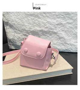 Pink mini crossbody lipstick bag in smooth faux leather on a decorative setup