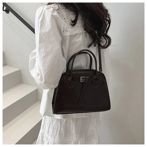 Dark brown matte bowling bag with dual handles and strap shown on a model
