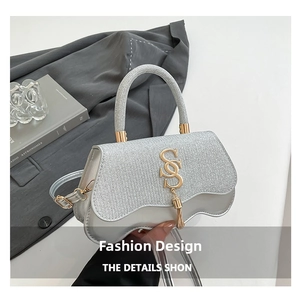 Close-up of silver glitter handbag with gold SS logo and unique wavy base detail