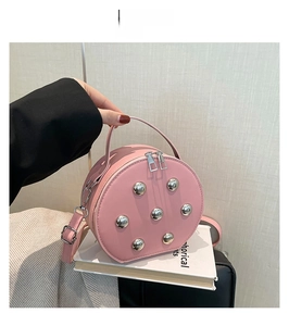 Detailed macro view of the pink round bag showing silver ball studs and leather texture