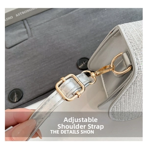 Detail of adjustable shoulder strap with gold metal buckle on silver sequin handbag