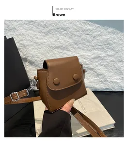 Detail of brown mini crossbody bag in matte PU leather with dual buckles and silver strap