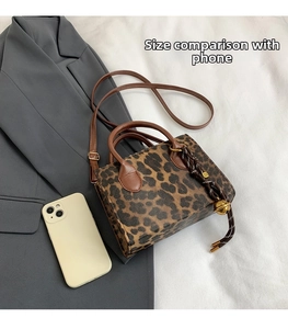 Detailed view of leopard print crossbody bag with smartphone for size comparison