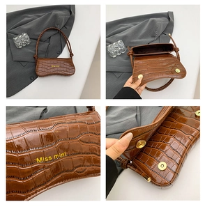 Macro detail of brown crocodile embossed leather with gold magnetic closure and branding