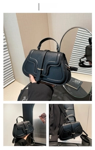 Detail of black lychee grain leather handbag featuring gold hardware buckle and stitching