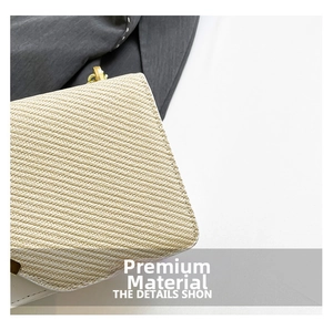 Detail of beige woven fabric texture and premium metal hook on the crossbody bag