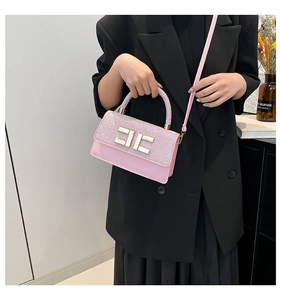 Détail d'un sac bandoulière rose avec paillettes, boucle métal et finitions dorées