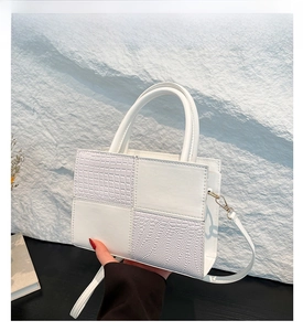 Détails d'un sac à main blanc en simili cuir avec motifs crocodile et autruche texturés