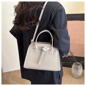 Rear view of a model wearing the cream-white square shell bag with lychee texture leather