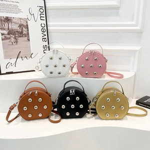 Trendy round crossbody bags with rivets in five colors shown on minimalist display