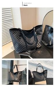 Detail of black tote bag with M letter print and circular metal logo charm accessory