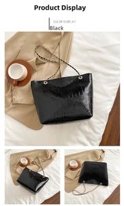 Detail of black crocodile texture tote bag with metallic chain strap for women
