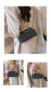 Close-up of black evening clutch bag with golden handle and metal chain strap