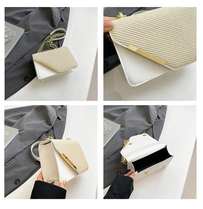 Detail of two-tone woven leather crossbody bag with gold chain and magnetic snap closure