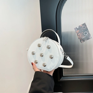 Sac rond blanc tendance avec clous argentés sphériques et poignée élégante