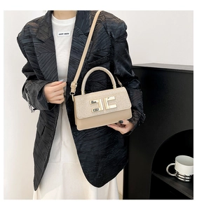 Détail d'un sac à main beige avec patchwork de paillettes et boucle en métal doré