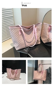 Detail of pink tote bag featuring all-over M pattern and gold M-shaped metal pendant