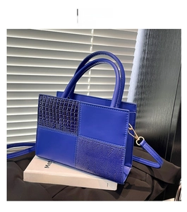 Détail du cabas bleu en patchwork avec cuir embossé crocodile et ferrures dorées