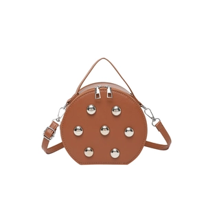 Brown leather round crossbody bag with silver studs and chain strap in minimalist design