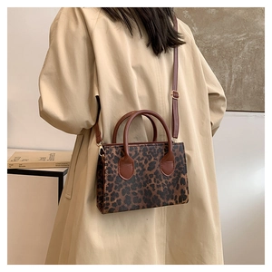Detailed side view of leopard print tote bag styled with a classic beige trench coat