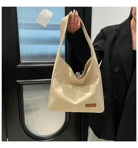 Detail of cream large faux leather tote bag with wide shoulder strap and outer pocket