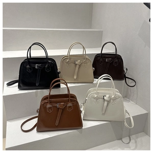 Detail view of stylish trapezoid tote bags in five classic colors on stone stairs