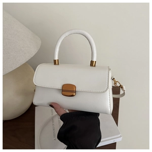 Détail du sac à main en cuir blanc avec boucle en métal doré et poignée élégante
