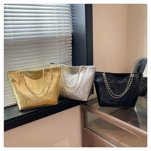 Three crocodile embossed tote bags in gold silver and black with chain straps