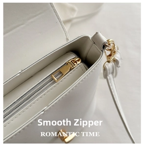 Detailed interior of white bucket bag showing smooth golden zipper and lining