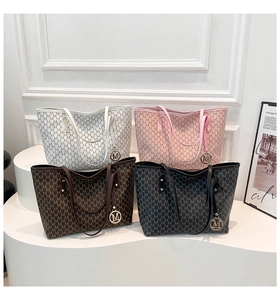 Detail view of large tote bags in four colors with M-letter pattern and metal charm