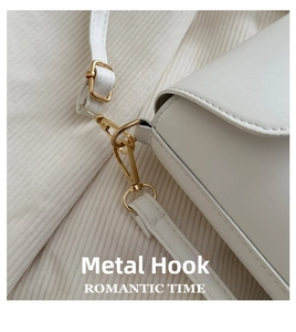 Detail of elegant gold metal swivel hook and white leather shoulder strap connection