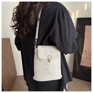 Détail du sac bandoulière tissé beige avec broderie florale délicate et fermoir doré