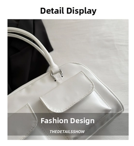 Detail of white faux leather handbag with multi-pocket design and silver metal rings