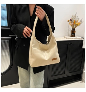 Detailed side view of cream white minimalist PU leather tote bag with rectangular tag