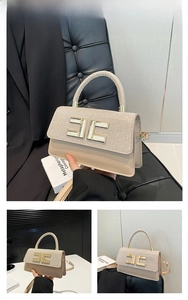 Détail d'un sac à main doré de luxe avec paillettes et logo métallique sur le rabat