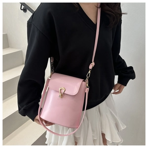Detailed view of pink PU leather crossbody bag featuring a unique gold metal buckle