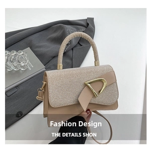 Detail of beige glitter patchwork bag with gold metal buckle and sturdy handle