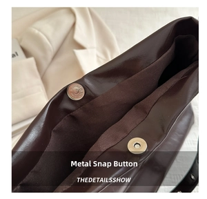 Close-up of magnetic snap closure on dark brown matte leather tote bag with canvas lining