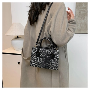 Black and silver leopard print handbag styled with a beige coat in a minimalist interior