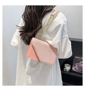 Detail of pink patchwork crossbody bag with gold metal trim and elegant chain strap