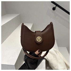 Détail du sac demi-lune marron foncé avec texture cuir mat et fermoir doré rotatif