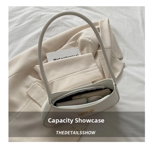 Internal storage view of white bow shoulder bag with phone and wallet inside