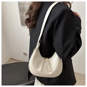 Detailed view of cream crescent hobo bag with gold hardware and long leather zipper pulls