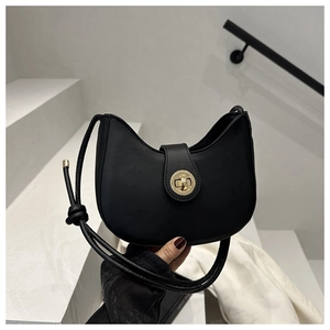 Détail du sac croissant noir en similicuir lisse avec fermoir rotatif en métal doré chic