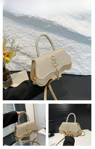 Detailed close-up of golden glitter handbag with metal tassel and decorative S-shaped logo
