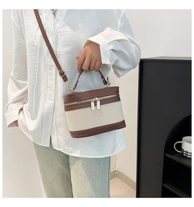 Close-up of vintage canvas patchwork box bag with brown leather details and metal zippers